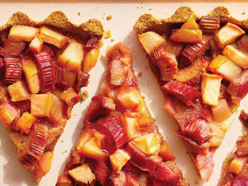 Four slices of Rhubarb and Pear Tart on a large rectangle cream plate, placed with space between each slice