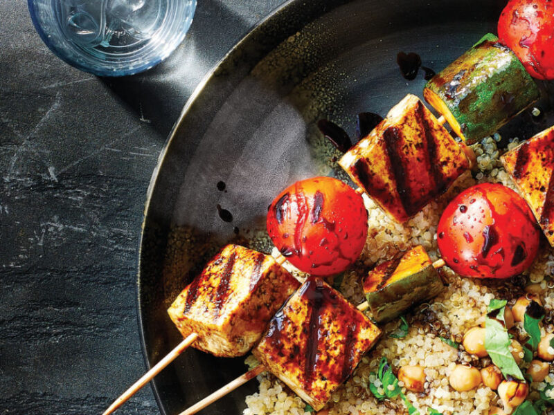 Grilled Tofu Kabobs with Rhubarb-Balsamic Glaze and Quinoa Pilaf in a stainless steel pan on a a dark countertop