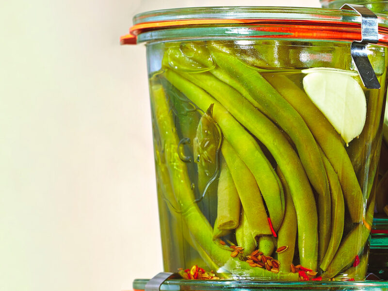 A couple of air-tight jars of Spicy Pickled Green Beans stacked on top of each other