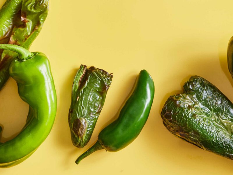 a few air-fryer roasted chile peppers shown on a yellow background