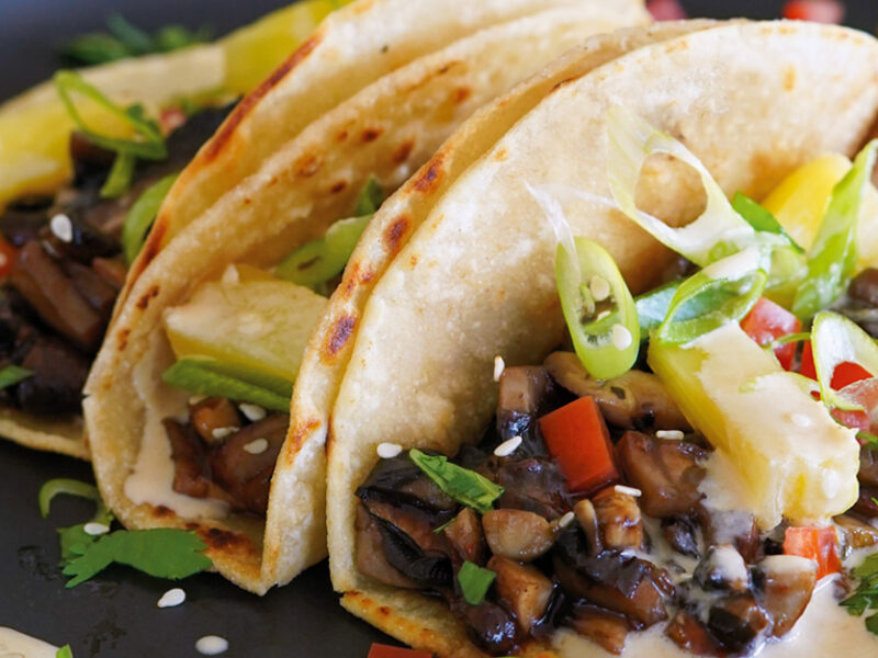 Three of Kiki Nelson’s Hawaiian Street Cart Tacos on a dark plate with a wedge of lime