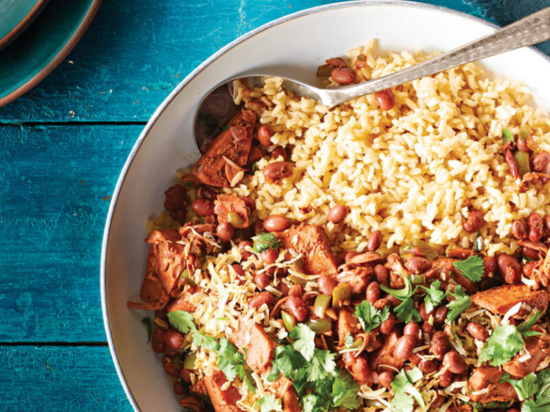 Jerk Jackfruit Skillet with Red Beans in a white bowl on a sea-blue table with a with blue cloth napkin