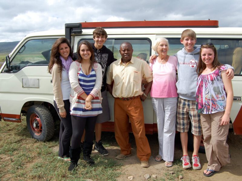 80-year old Beverly Kelly standing with her famliy in front of a van
