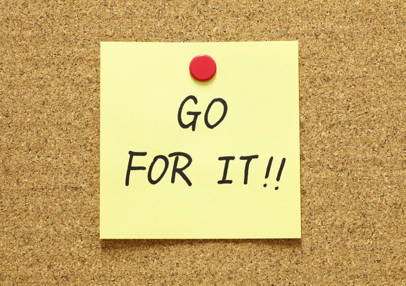 Post-it note pinned to cork board, with the words "GO FOR IT!!" written on it