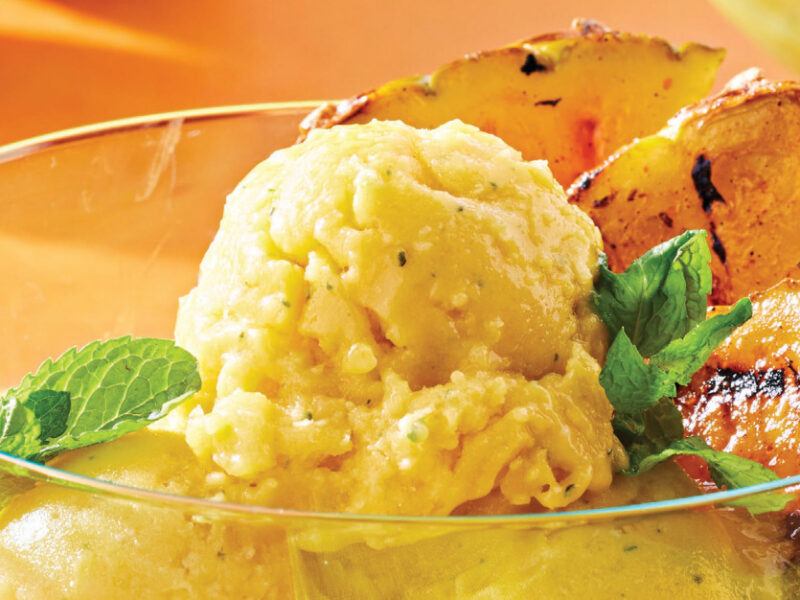 Grilled Pineapple with Minty Mango Nice Cream in a wide-mouthed glass dish garnished with fresh mint
