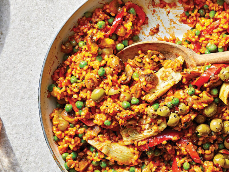 Easy Vegan Paella in a skillet with a wooden serving spoon resting in the dish