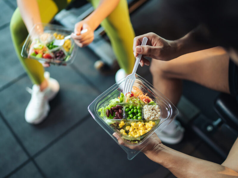 Shot of a man and woman eating a healthy vegan meal at the gym