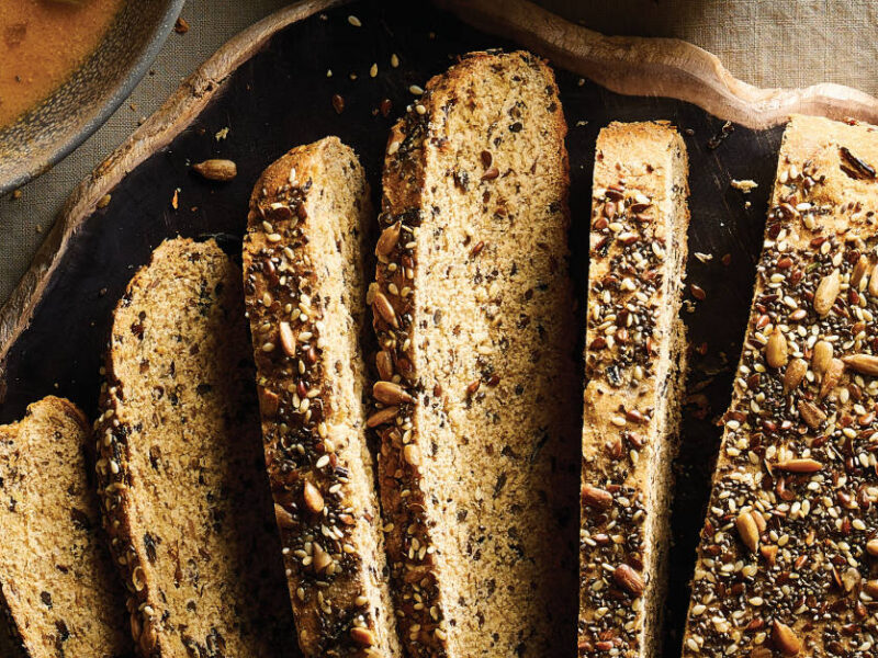 Seed Bread with Wild Rice and Herbs on a wooden platter cut into slices