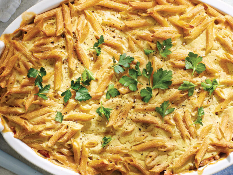 Vegan Pastitsio with Lentils (Greek Lasagna) in a white casserole dish garnished with flat leaf parsley