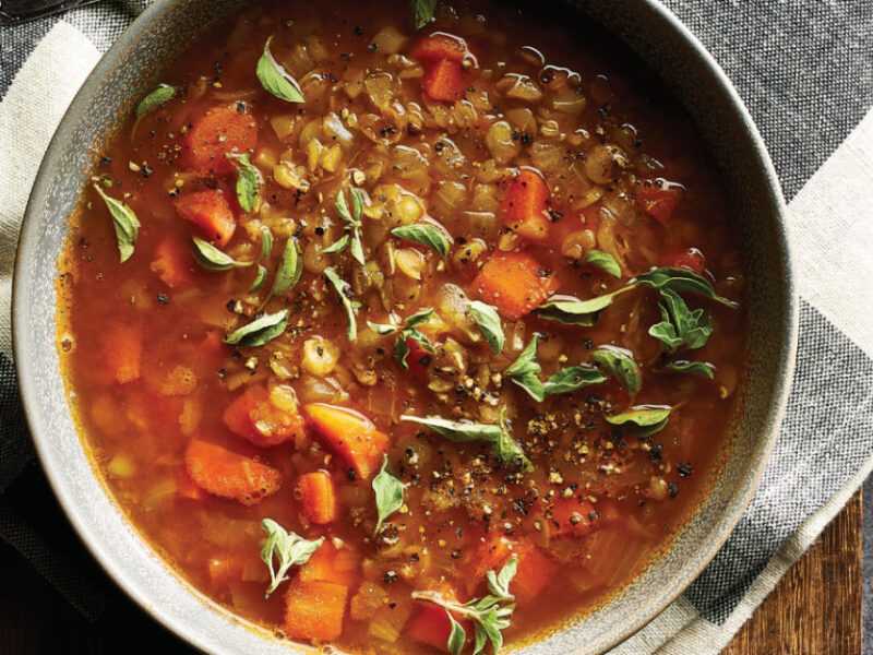 Smoky Vegan Split Pea Soup in a ceramic bowl on a black and white checked cloth napkin