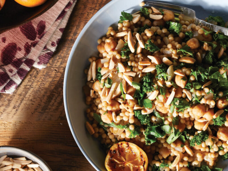 Za'atar-Seasoned Couscous with Kale and Charred Lemon in a wide-rimmed serving bowl with a fork