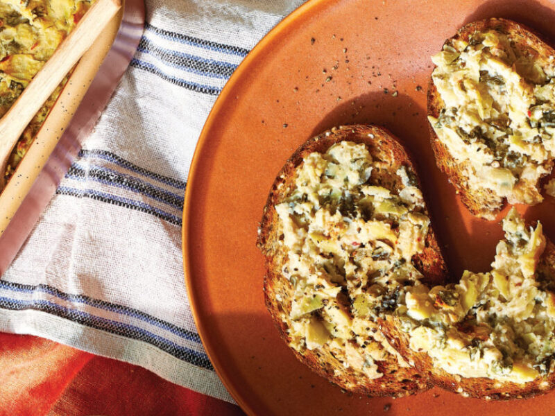 Whole grain toast spread with Baked Kale and Artichoke Dip