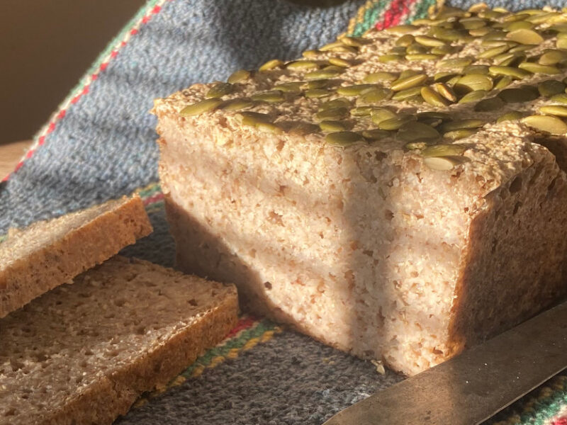 A loaf of buckwheat bread topped with pumpkin seeds