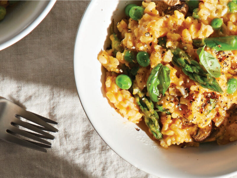 Easy Gluten-Free Risotto in a white serving bowl on a white tablecloth next to two forks