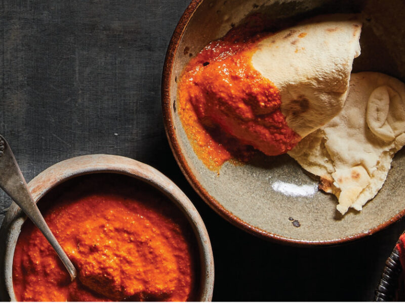 A plate with No-Fry Fryboread dipped in Tomato Pepita Sauce next to a small ceramic bowl of the sauce