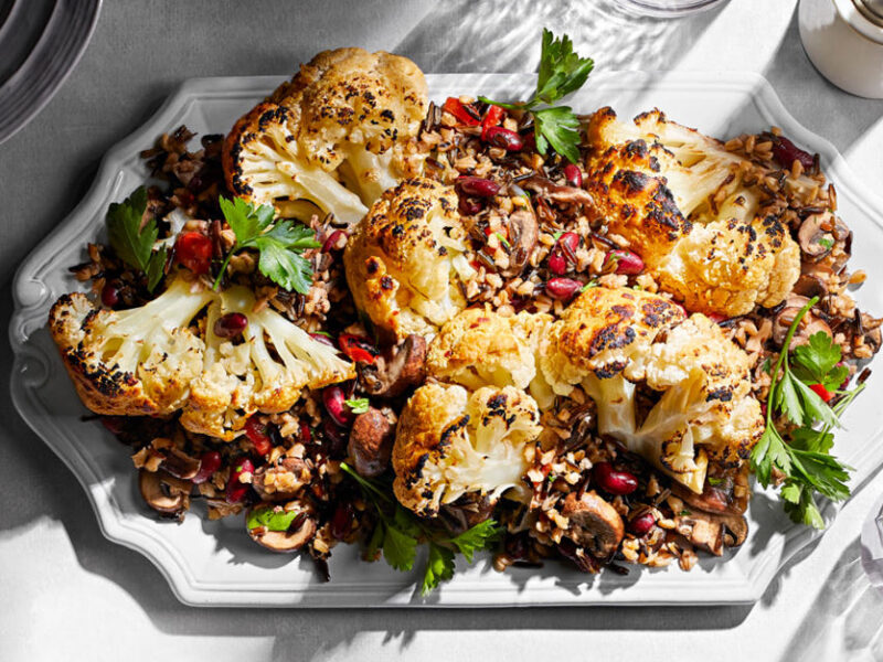Whole Braised Cauliflower with Mixed-Grain Pilaf on a white serving platter
