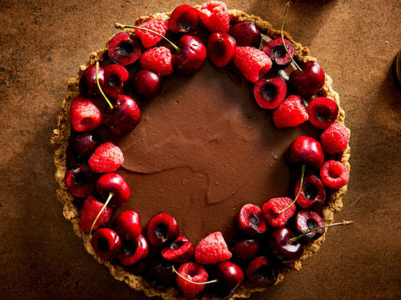Silky Vegan Chocolate Ganache Tart garnished with fresh cherries and raspberries