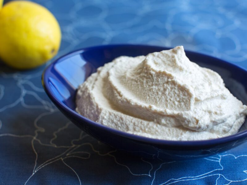 Tofu Sour Cream in a blue bowl with a lemon in the background