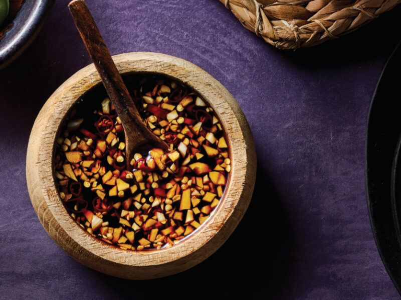 Garlic Dipping Sauce in a rustic brown bowl with a small wooden spoon resting in the bowl