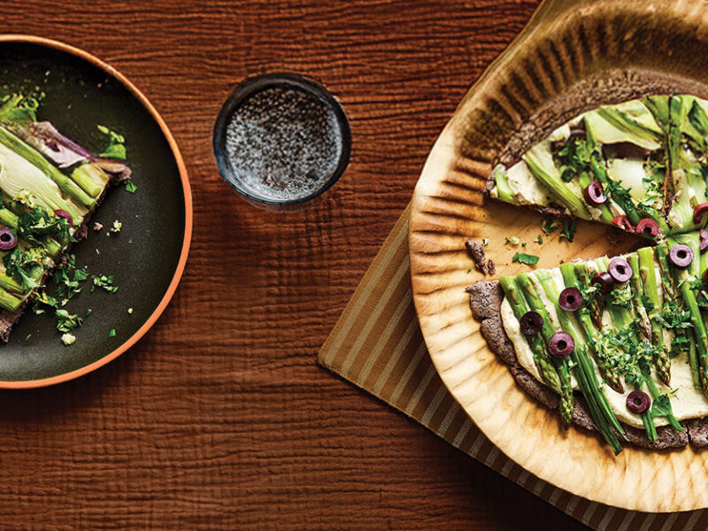 Spring Onion and Asparagus Tarts with Black Bean Crust on a dinner-sized plate, with one slice removed on a smaller plate