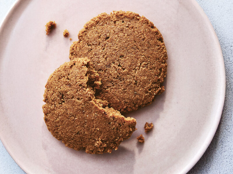Molasses Spice Cookies on a plate, with a large bite out of one cookies