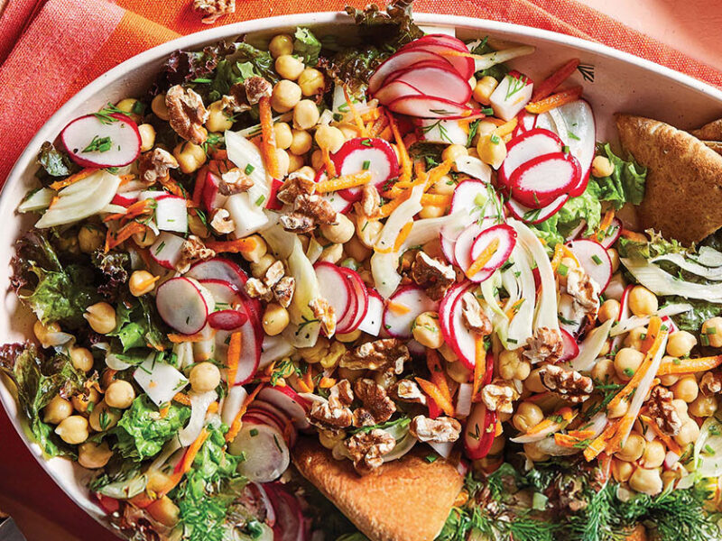 Chickpea, Fennel and Radish Salad on a large white serving platter on a red and pink checked kitchen towel