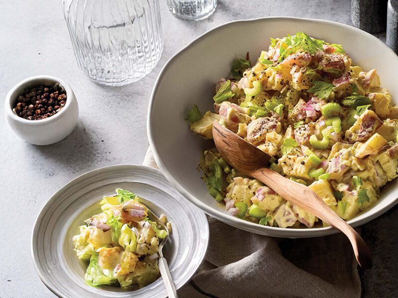 Del Sroufe's vegan Potato Salad in a bowl with a wooden serving spoon