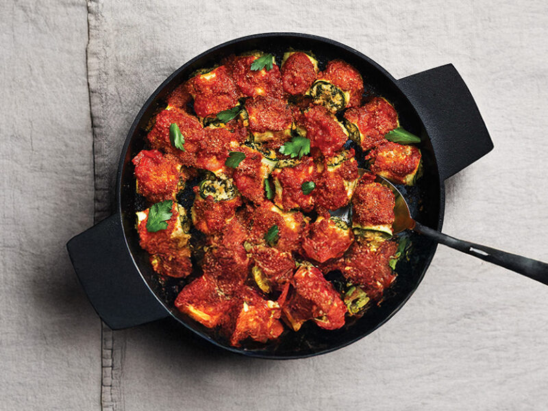 Zucchini Rollatini in a cast-iron skillet on grey cotton tablecloth