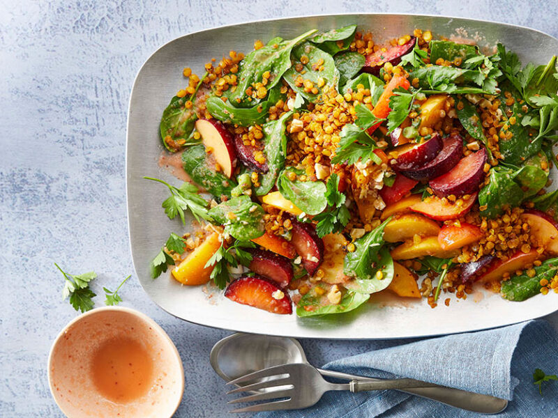 Plum Spinach Salad with Lentils on a large white platter