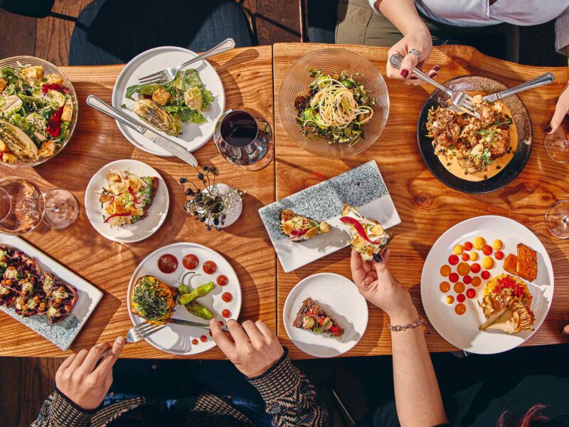 A top-down shot of a spread of vibrant plant-based dishes at upscale NYC vegan restaurant Avant Garden