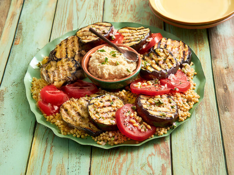 Greek-Style Grilled Eggplant Steak Supper on a platter with a bowl of hummus