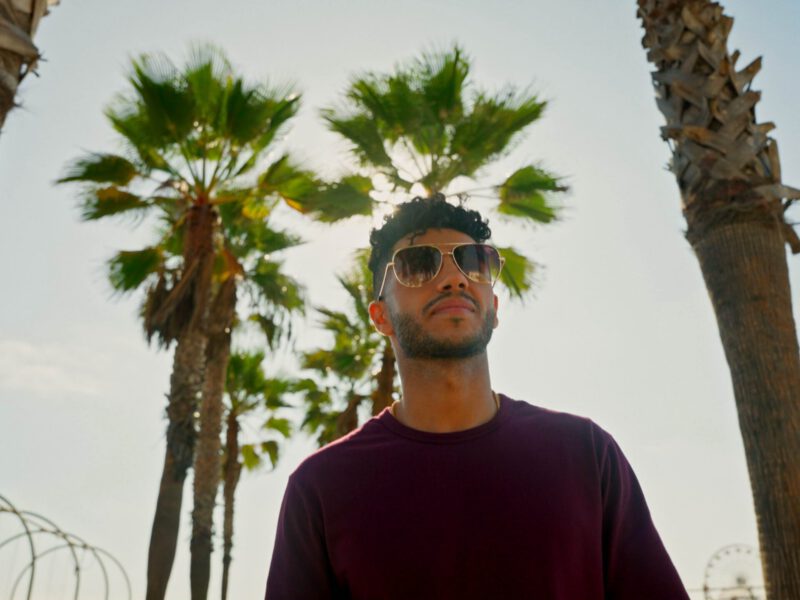 Mena Massoud walks down a los angeles street in a still from his show evolving vegan