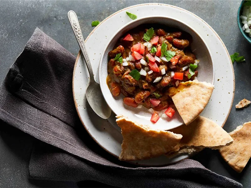 Instant Pot Kidney Bean Dal in a white bowl with pita squares on the side