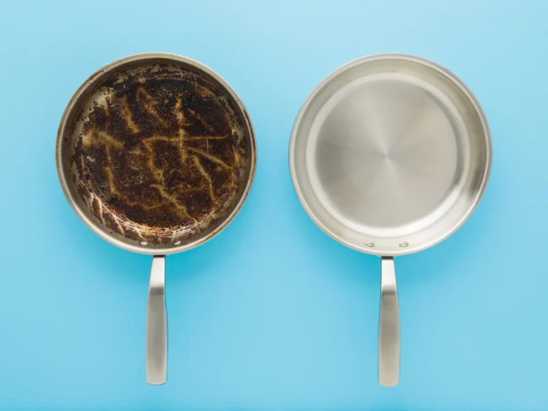 two stainless steel pans - on the left, one is caked in burnt food and grease - on the right is a perfectly clean stainless steel pan without anything sticking to it