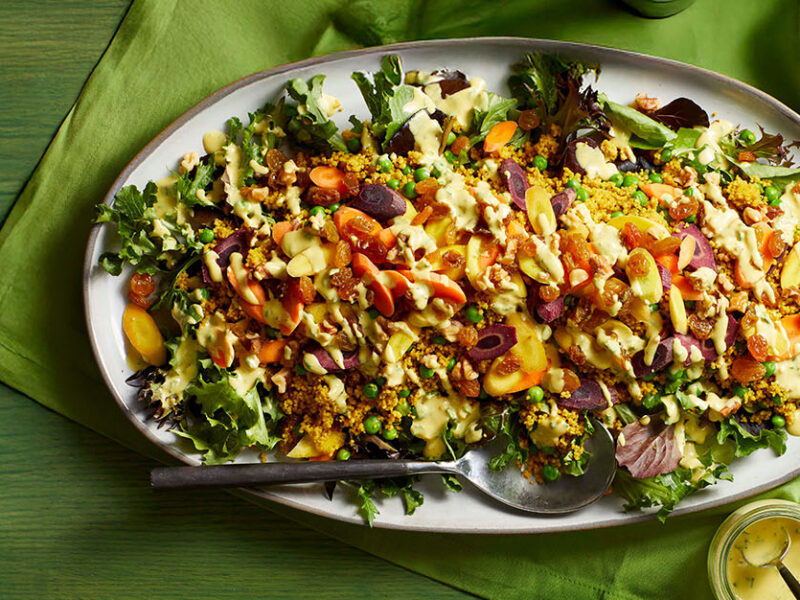 A large platter of Farmers Market Couscous Salad on a green table cloth
