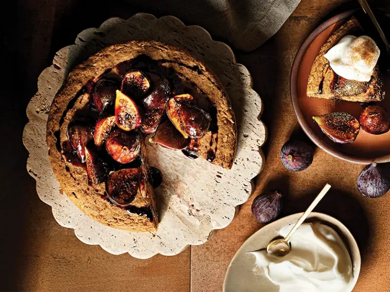 Vegan Apple Cake with Maple-Glazed Figs on a plate, with one slice removed and served on a plate with a dollop of aquafaba whipped cream