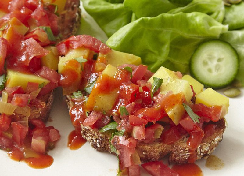 Vegan Potato Scramble with Hot Chile Sauce on a plate with lettuce and cucumber