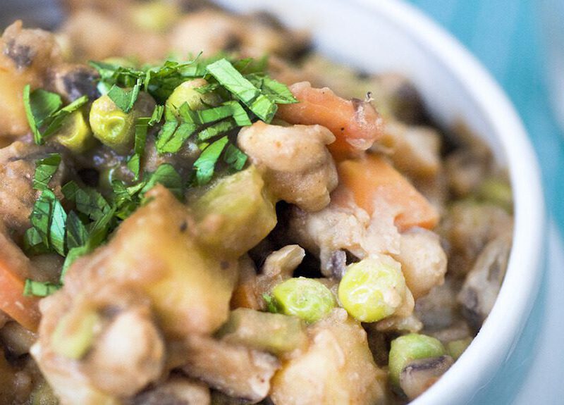 Close up of Black-Eyed Pea BBQ Stew in a white bowl with a fork out of focus in the background