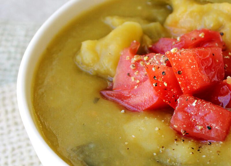A close up of Split Pea & Yam Soup in a white bowl on a white placemat