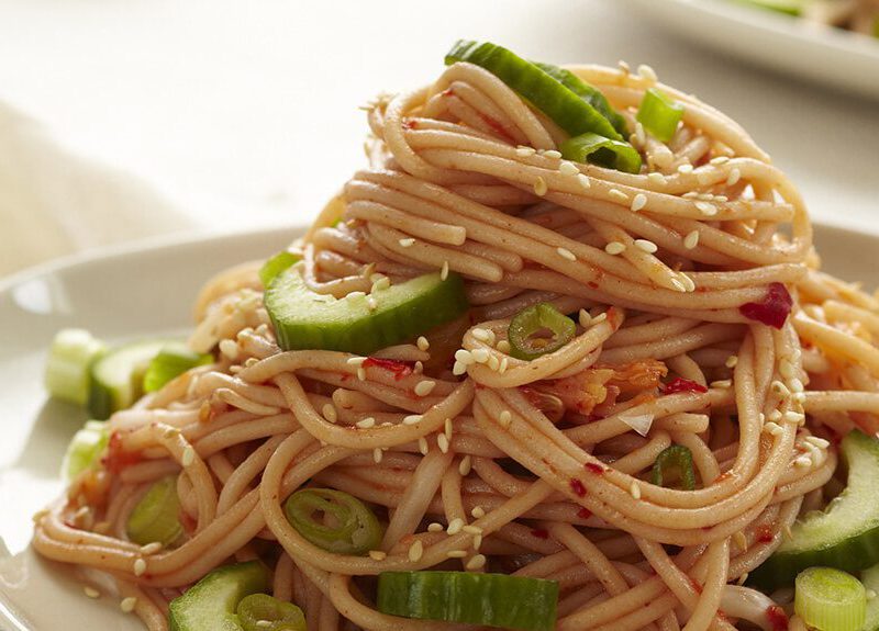 Kimchi Noodle Salad against a white background with chopsticks to the side