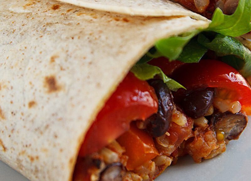 Close-up of one end of a Burrito with Spanish Rice and Black Beans on a plate