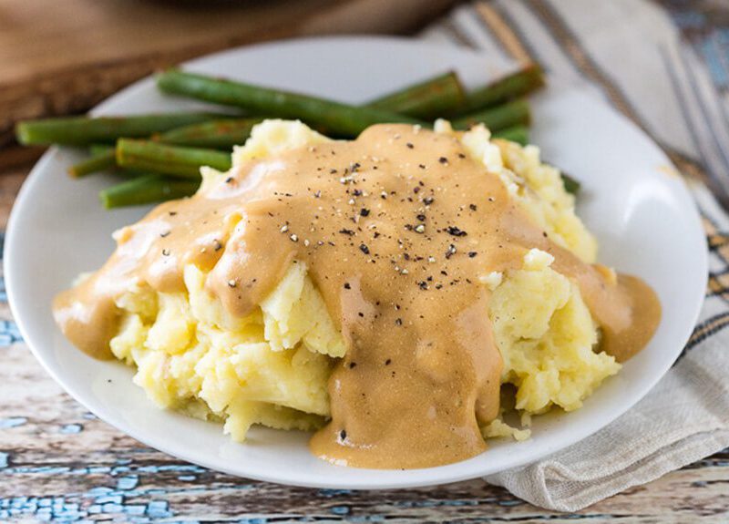 Heather's Garlic Mashed Potatoes and Creamy Golden Gravy on a plate with asparagus spears