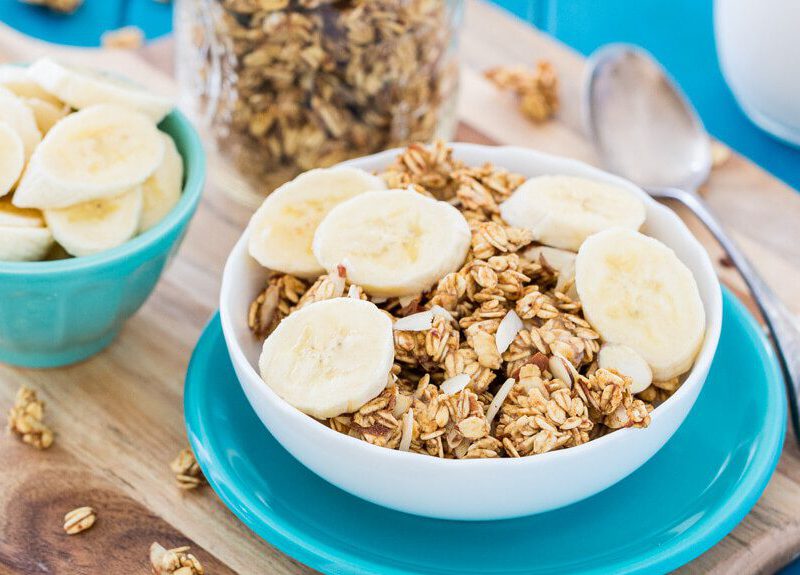 vegan granola sweetened with bananas in a white bowl on a blue plate
