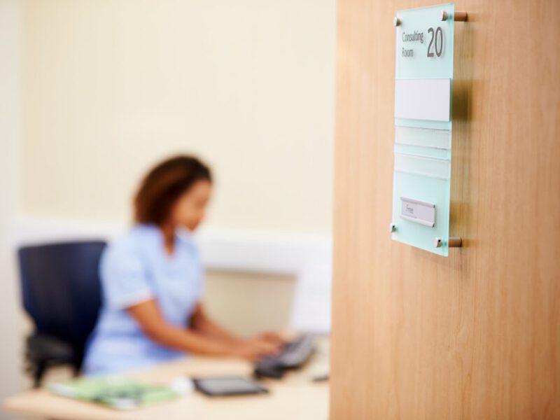 Female Nurse Working At Desk In Office