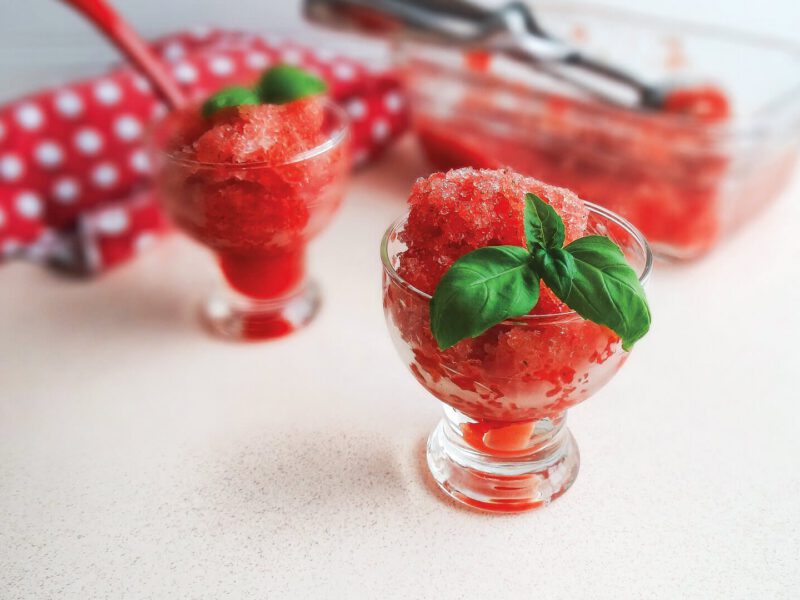 Two servings of Watermelon-Basil Ice in short-stemmed glasses with a large dish of the ice in the background