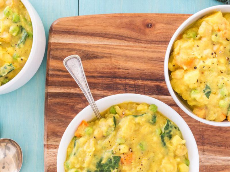 Three bowls of Creamy Potato Curry with a chopping board