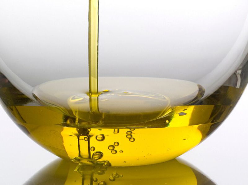Fresh olive oil pouring into a bowl