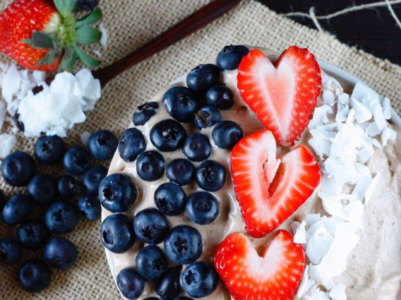2-Ingredient Chocolate Banana Ice Cream garnished with sliced strawberries, blueberries, and coconut shreds