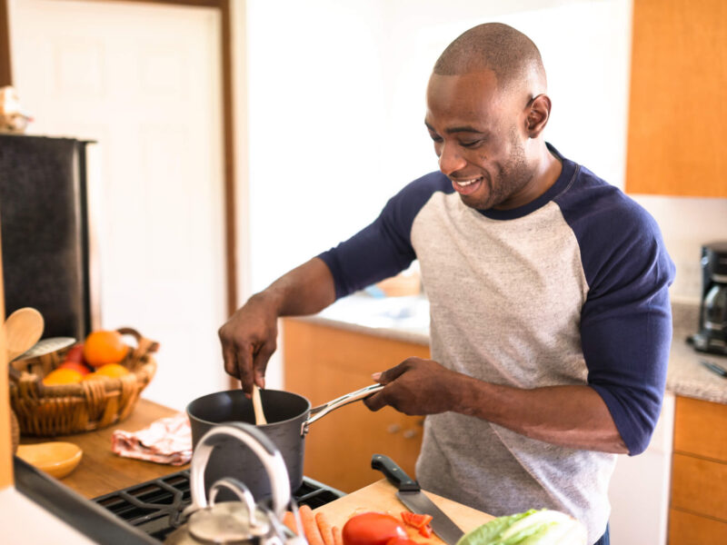 happy man standing on the kitchen and preparing food