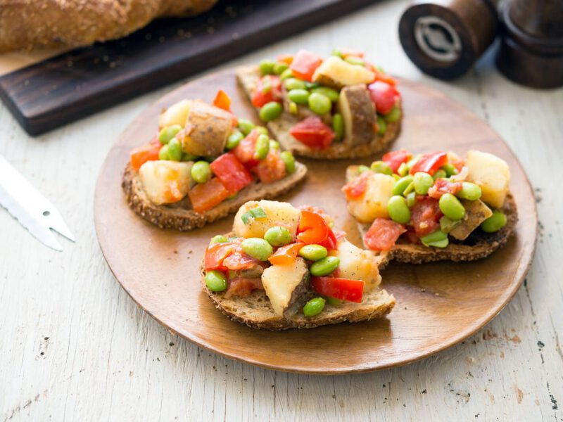 Four slices of Potato-Edamame Hash on Toast on a wooden plate